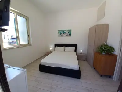 a bedroom with a bed in a room with a window at Villa Rosa in Castellammare del Golfo