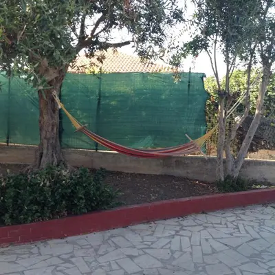 a hammock tied to a tree next to a fence at Villa Rosa in Castellammare del Golfo