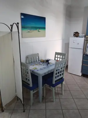 a table and chairs in a kitchen with a refrigerator at Dolce Casa in Palermo