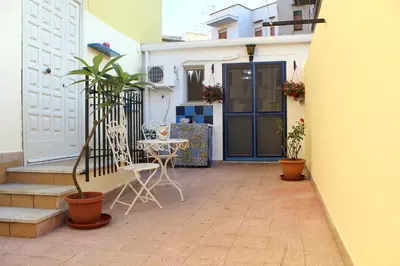 a patio with a table and chairs in front of a house at Dolce Casa in Palermo