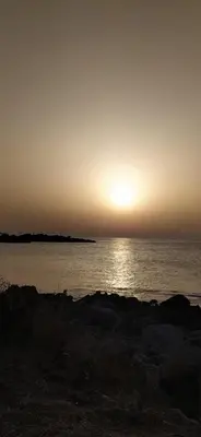 a sunset over the ocean with the sun setting at Dolce Casa in Palermo