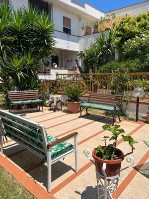 a group of benches in a courtyard with plants at Trentuno Mondello Apartments in Mondello