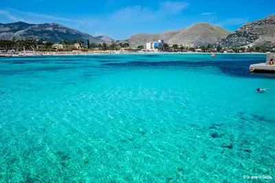 a view of the ocean with mountains in the background at Trentuno Mondello Apartments in Mondello