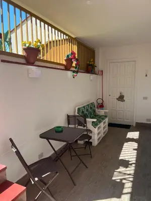 a living room with a table and chairs and a staircase at Trentuno Mondello Apartments in Mondello