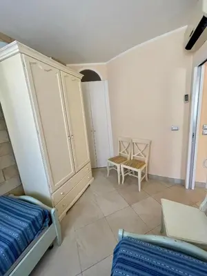 a room with a bed and a cabinet and a chair at La Casa di Martorana in Palermo
