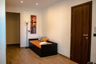 a small bedroom with a bed and a door at Casa Vespucci in Isola delle Femmine