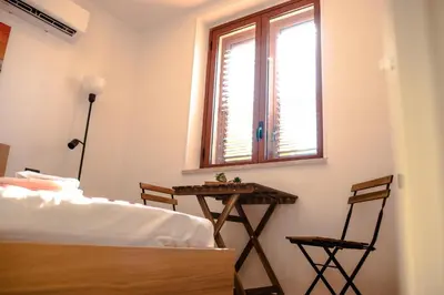 a bedroom with a bed and a table and a window at Casa Vespucci in Isola delle Femmine