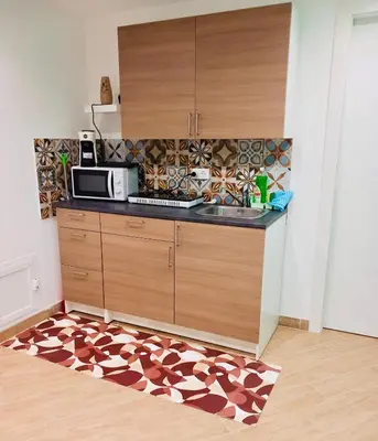 a kitchen with a microwave and a kitchen rug at Pindemonte Suites in Palermo
