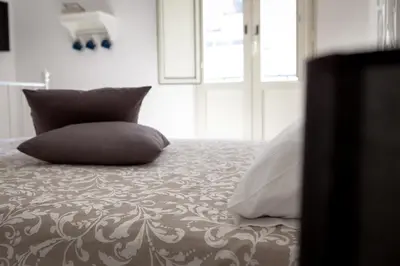 a bed with two pillows on it in a bedroom at Pindemonte Suites in Palermo