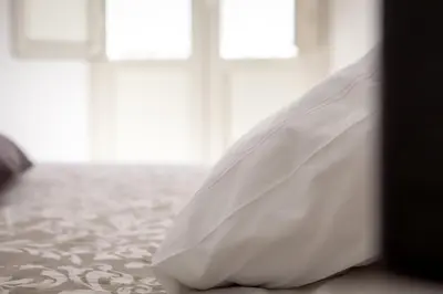 a white wedding dress sitting on a bed at Pindemonte Suites in Palermo