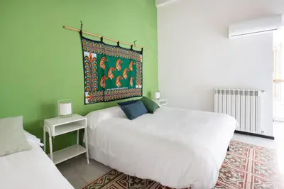 a bedroom with two beds and a painting on the wall at Iconic Apartment in Porta Carini by Wonderful Italy in Palermo