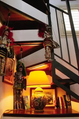 a room with a table with a lamp and books at DAI MORI in Palermo