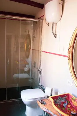 a bathroom with a toilet and a glass shower at DAI MORI in Palermo