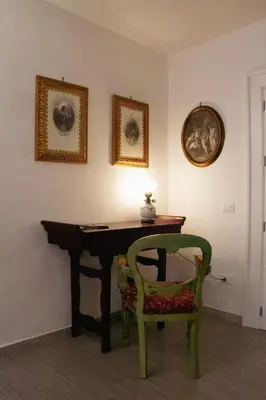 a room with a table and a chair and a lamp at DAI MORI in Palermo