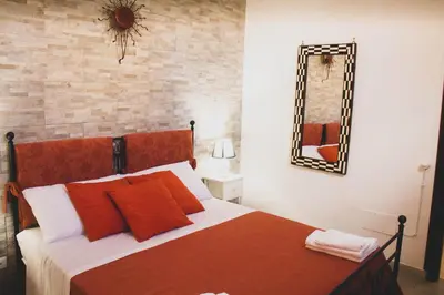 a bedroom with a bed with red pillows and a mirror at DAI MORI in Palermo