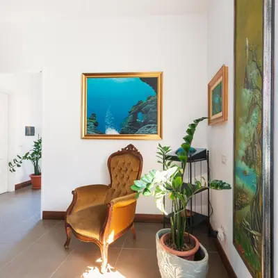 a living room with a chair and a plant at A Casa Dell' Artista in Palermo