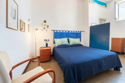 a bedroom with a blue bed and a chair at A Casa Dell' Artista in Palermo