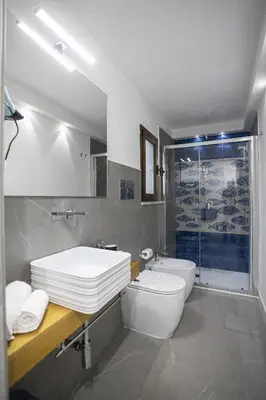 a bathroom with a sink and a toilet and a shower at Acquarò Suite Apartments in San Vito lo Capo