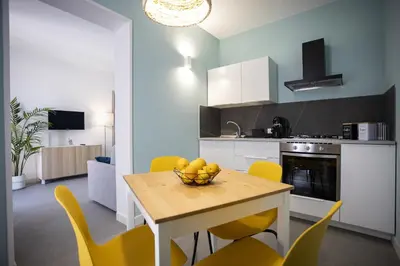a kitchen with a table with a bowl of fruit on it at Acquarò Suite Apartments in San Vito lo Capo