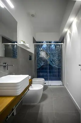 a bathroom with a shower and a toilet and a sink at Acquarò Suite Apartments in San Vito lo Capo
