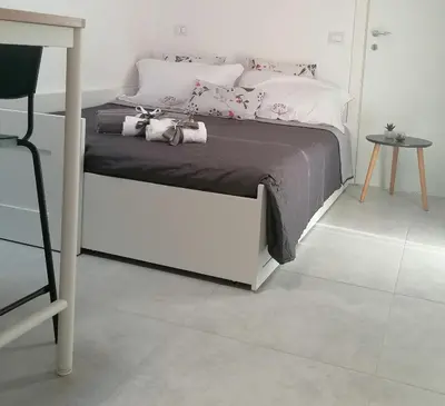 a bedroom with a bed and a table and a chair at Nella House in Castellammare del Golfo