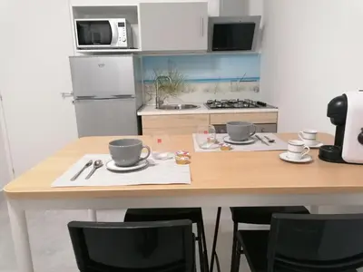 a kitchen with a wooden table with two cups on it at Nella House in Castellammare del Golfo