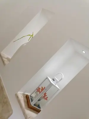 a glass table with a shelf and a vase at Nella House in Castellammare del Golfo