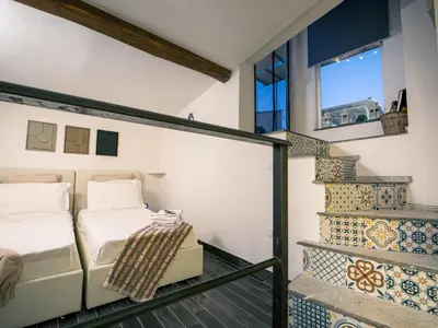 a bedroom with a bed and a stair case at Baglio Colonna - Nature Noble Boutique in Partinico