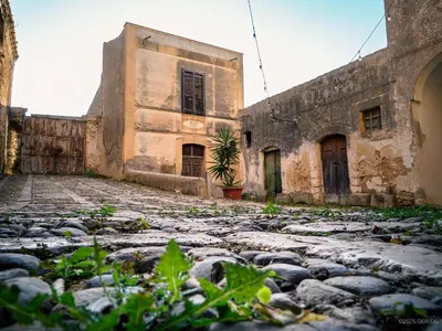 an old building with a stone ground in front of it at Baglio Colonna - Nature Noble Boutique in Partinico