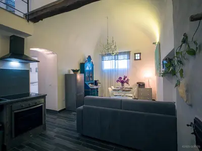 a living room with a couch and a kitchen at Baglio Colonna - Nature Noble Boutique in Partinico