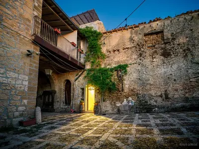 an alley in an old building with a yellow door at Baglio Colonna - Nature Noble Boutique in Partinico