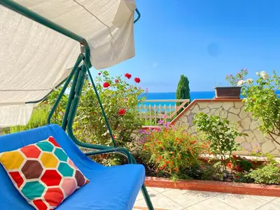 a porch swing with a view of the ocean at Villa Mare Giuggiola in Alcamo Marina