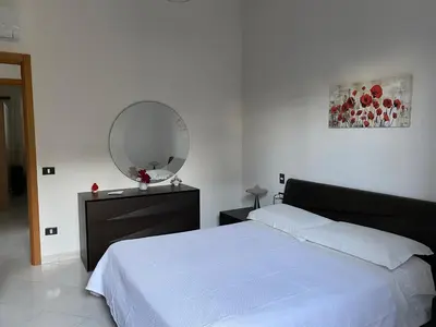a bedroom with a white bed and a mirror at Villa Mare Giuggiola in Alcamo Marina