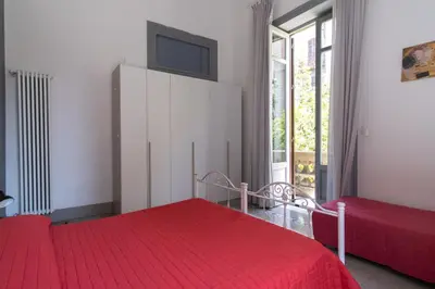 a bedroom with two beds with red sheets and a tv at Rome 118 in Palermo