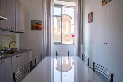 a kitchen with a table and chairs and a window at Rome 118 in Palermo