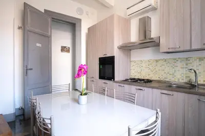 a kitchen with a white table with a flower on it at Rome 118 in Palermo