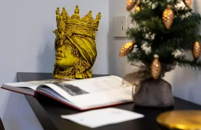 a gold crown sitting on a table next to a book at Vespri Luxury Rooms & Suites in Palermo