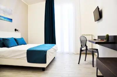 a bedroom with a bed and a desk and a chair at Leone Apartments in Palermo