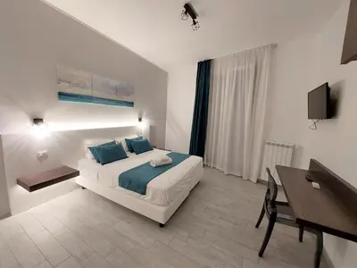 a bedroom with a bed and a table and a desk at Leone Apartments in Palermo