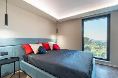 a bedroom with a bed with a large window at Villa vista mare con piscina a sfioro a Scopello in Castellammare del Golfo