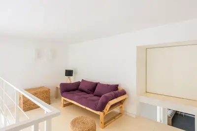 a living room with a purple couch and a staircase at Casa Roma nel Cuore di Palermo by Wonderful Italy in Palermo