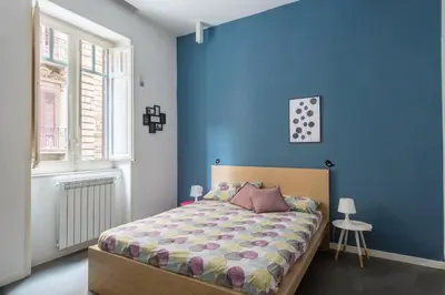 a blue bedroom with a bed and a window at Casa Roma nel Cuore di Palermo by Wonderful Italy in Palermo