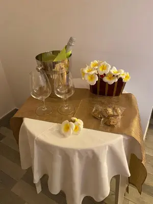 a table with a cupcake and two glasses and flowers at B&B Torre Pozzillo in Cinisi