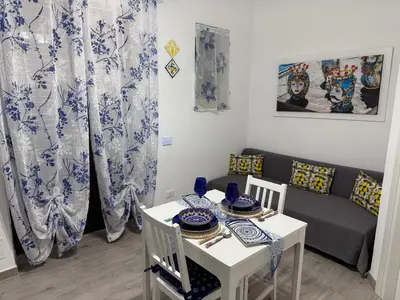 a living room with a table and a couch at Casetta Blu Mondello zona Partanna in Palermo