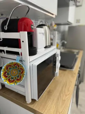a counter in a kitchen with a microwave and a red appliance at Casetta Blu Mondello zona Partanna in Palermo