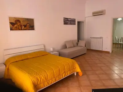 a bedroom with a yellow bed and a couch at Casa arancio in Palermo