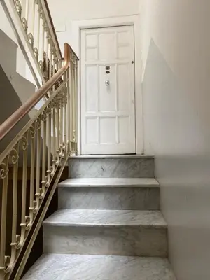 a stairway with a white door and some stairs at Casa arancio in Palermo