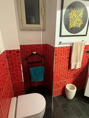 a bathroom with a toilet and red tiles at ART GALLERY HOUSE La casa dell’arte in Palermo
