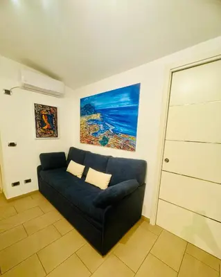 a living room with a blue couch and a painting at ART GALLERY HOUSE La casa dell’arte in Palermo