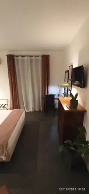 a bedroom with a bed and a desk with a television at Jacona 365 in Palermo